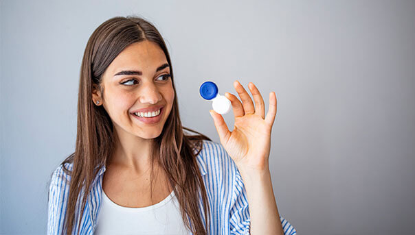 Woman smiling holding rigid gas permeable lenses care from Big City Optical