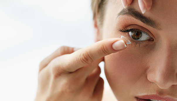 Woman putting on hybrid contacts at Big City Optical